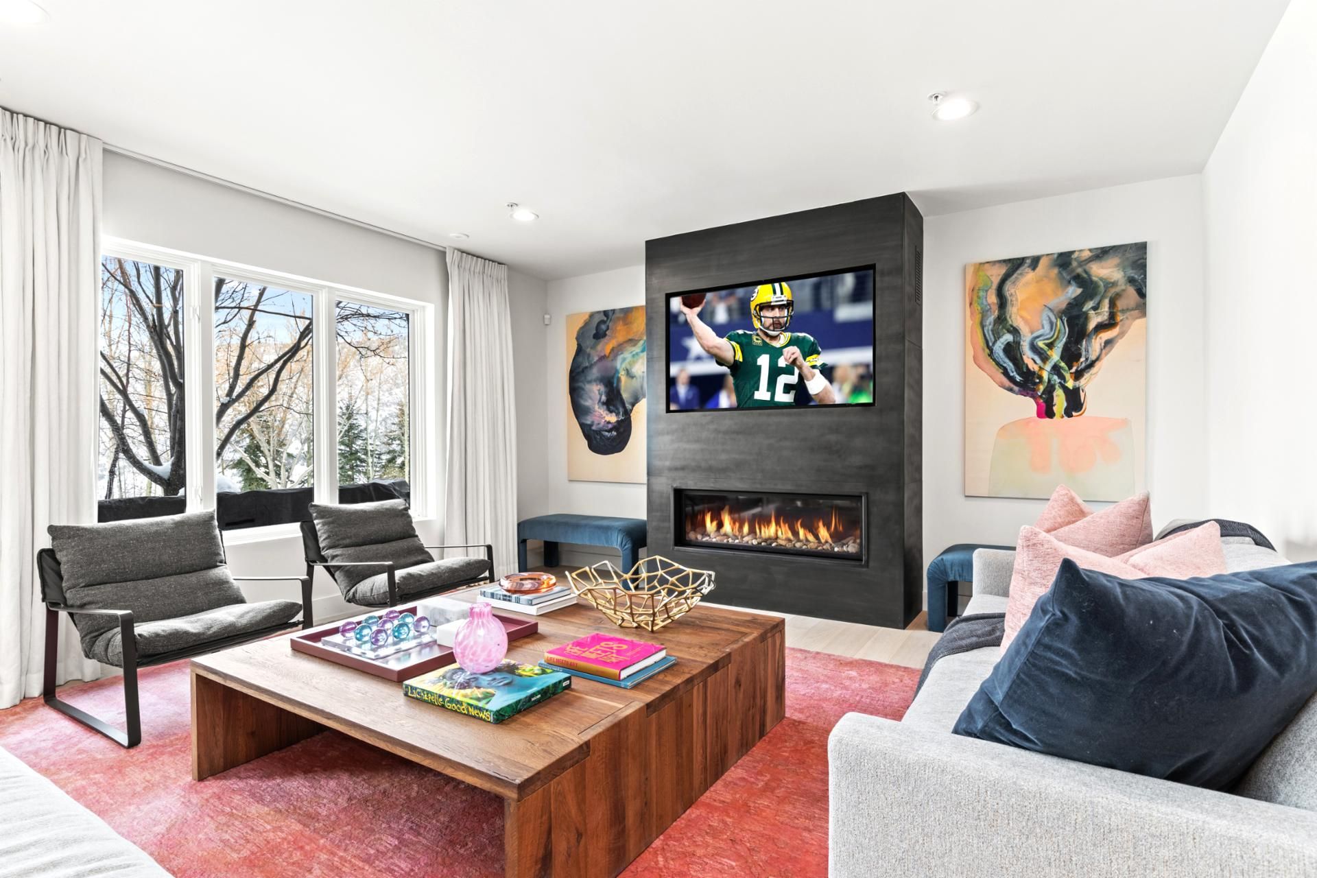 A modern living room with a fireplace, a television, and artwork on the walls.