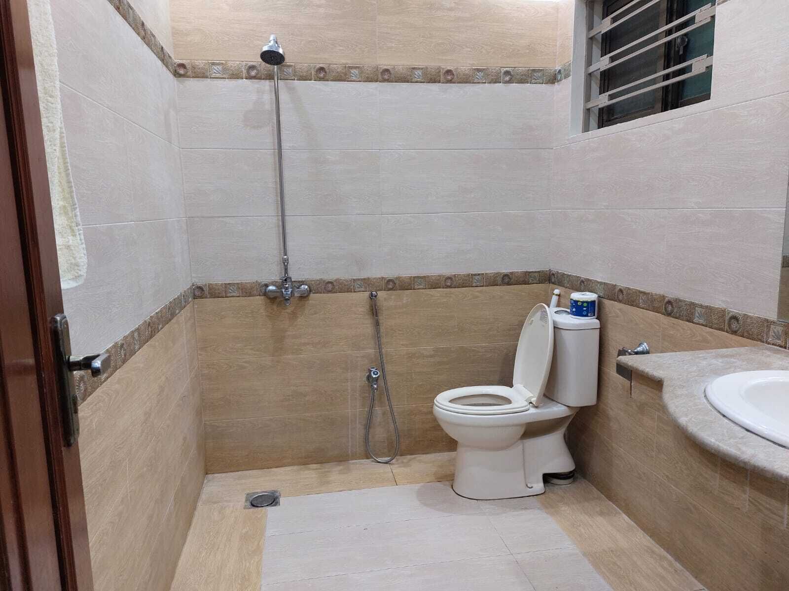 A small bathroom with a toilet, a shower, and a sink.