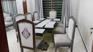 A dining room with a rectangular table, six chairs, and a decorative mirror. - Beautiful 3-bed House in Islamabad (Rawalpindi)