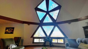 A living room with a high ceiling, exposed wooden beams, and a large skylight. - Dome House on Whitewater Lake (Whitewater)
