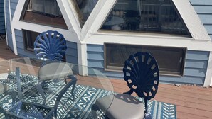 A house with a unique triangular window design, a visible deck area, and outdoor furniture. - Dome House on Whitewater Lake (Whitewater)