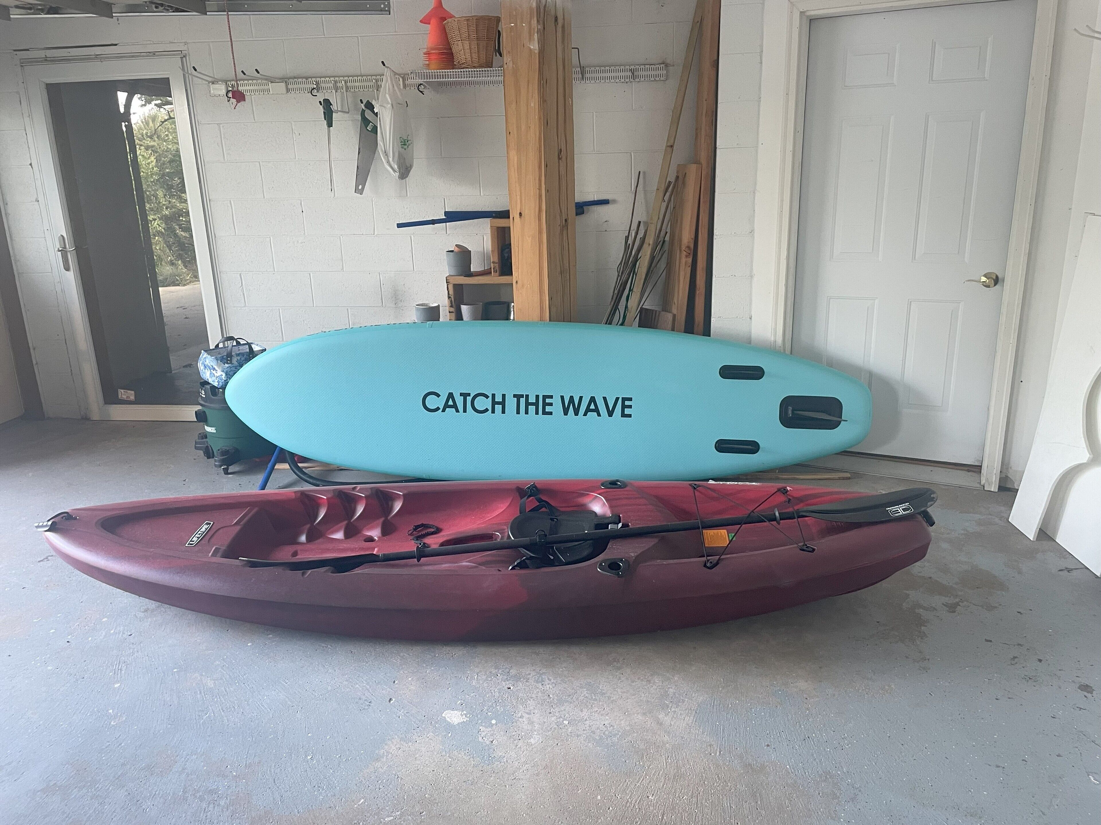 Un garaje con un kayak y una tabla de surf.