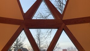 A room with a large skylight featuring a geometric wooden frame and multiple panes. - Dome House on Whitewater Lake (Whitewater)
