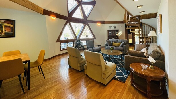 A spacious living area with a high ceiling, wooden beams, and large windows. - Dome House on Whitewater Lake (Whitewater)