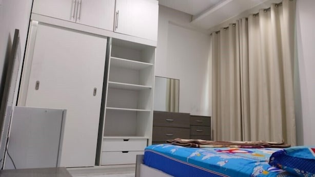 Une chambre à coucher avec un lit, une armoire, un bureau et un miroir.