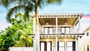 Une maison à deux étages avec un balcon, une boîte aux lettres et une pelouse bien entretenue.