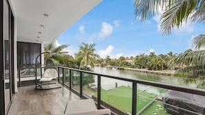 A balcony with a view of a river and palm trees. - Playa Villa - Modern Luxury Redefined (Miami Beach)