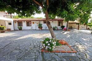 A courtyard with a stone floor, a tree, and potted plants. - Country house near the sea Luna (Sant'Alessio Siculo)