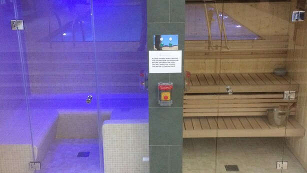 Un hammam avec un panneau indiquant qu’il faut prendre une douche avant de sortir.