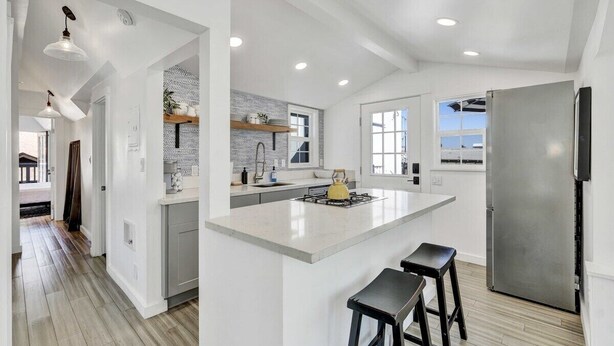 A modern kitchen with a large island, stainless steel appliances, and a view to the outside. - Modern A-Frame | Walkable | Two Balconies | Views (Avalon)