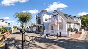 A street view of a residential area with houses, a clear sky, and a tree. - Modern A-Frame | Walkable | Two Balconies | Views (Avalon)