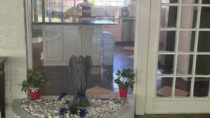 Een keuken met een vast kookeiland, een stenen open haard en uitzicht op de achtertuin.