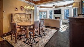 Un coin repas avec une table et des chaises en bois, un tapis à motifs et un lustre.