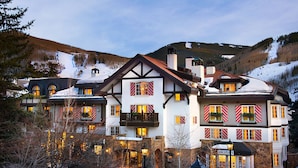 Un grand hôtel à plusieurs étages, de style architectural européen traditionnel, doté de balcons et de grandes fenêtres.