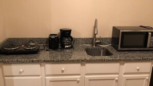 A kitchen with a granite countertop, a coffee maker, a microwave, and a sink. - Private, Quiet Ap. “Morning Singing Birds”, close to Phoebe (Albany)