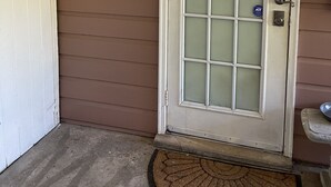 A front door with a frosted glass panel, a sign reading "MORNING SINGING BIRDS," and a doormat. - Private, Quiet Ap. “Morning Singing Birds”, close to Phoebe (Albany)