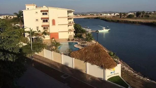 Un hotel con piscina, muelle para barcos y vistas al agua.