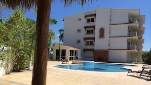 Zona de piscina con un edificio al fondo.