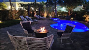 An outdoor patio area with lounge chairs, a fire pit, and a swimming pool. - Capri Cottage, Pool, walk to restaurants! (West Palm Beach)