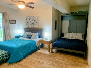 A bedroom with two beds, a ceiling fan, a painting, and a window with curtains. - Cozy Private Room-Queen&Full Bed, Hot Tub Pool Pets Welcome! (Milton)