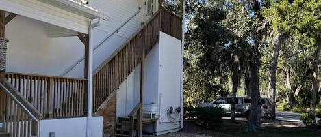 A two-story building with a porch, wooden steps, and a covered entryway.