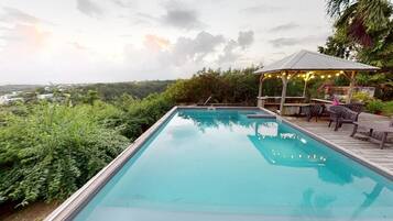 Una piscina al aire libre, sombrillas, tumbonas