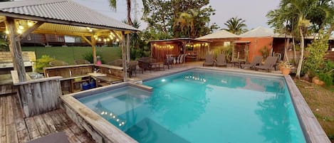 Una piscina al aire libre, sombrillas, tumbonas