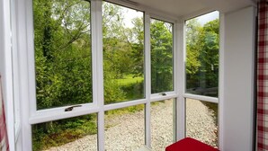 Una veranda con ampie finestre che si affaccia su un paesaggio verde.