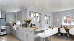 Una cucina moderna con isola centrale, elettrodomestici in acciaio inossidabile e illuminazione a sospensione.