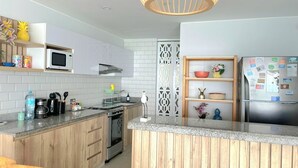 A modern kitchen with white cabinets, a wooden countertop, a stainless steel refrigerator, and a decorative wooden partition. - 𝐃𝐄𝐏𝐀 𝐂𝐎𝐍 𝐄𝐒𝐏𝐄𝐂𝐓𝐀𝐂𝐔𝐋𝐀𝐑 𝐕𝐈𝐒𝐓𝐀 𝐀𝐋 𝐌𝐀𝐑🌅 Punta Hermosa  (Punta Hermosa)