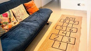 A modern living room with a dark blue sofa, colorful cushions, and a hopscotch rug. - 𝐃𝐄𝐏𝐀 𝐂𝐎𝐍 𝐄𝐒𝐏𝐄𝐂𝐓𝐀𝐂𝐔𝐋𝐀𝐑 𝐕𝐈𝐒𝐓𝐀 𝐀𝐋 𝐌𝐀𝐑🌅 Punta Hermosa  (Punta Hermosa)