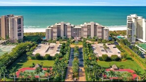 A resort with multiple high-rise buildings, a parking area, and a beach view.