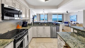A modern kitchen with granite countertops, stainless steel appliances, and a large island.