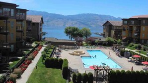 Un hotel con piscina, vistas a la montaña y un jardín bien cuidado.