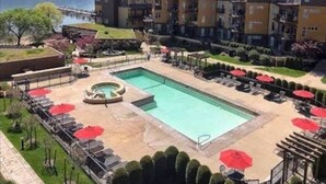 Um hotel com piscina, espreguiçadeiras e vista para montanhas.