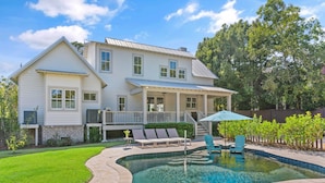 A two-story house with a swimming pool, a covered patio, and a well-maintained lawn. - Stollaway Retreat - 5 Bedrooms with Pool (St Simons Island)
