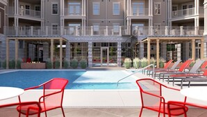 A hotel with a swimming pool, outdoor seating, and multiple balconies. - Magnificent 4BR House in Bloomington with Hot Tub (Bloomington)