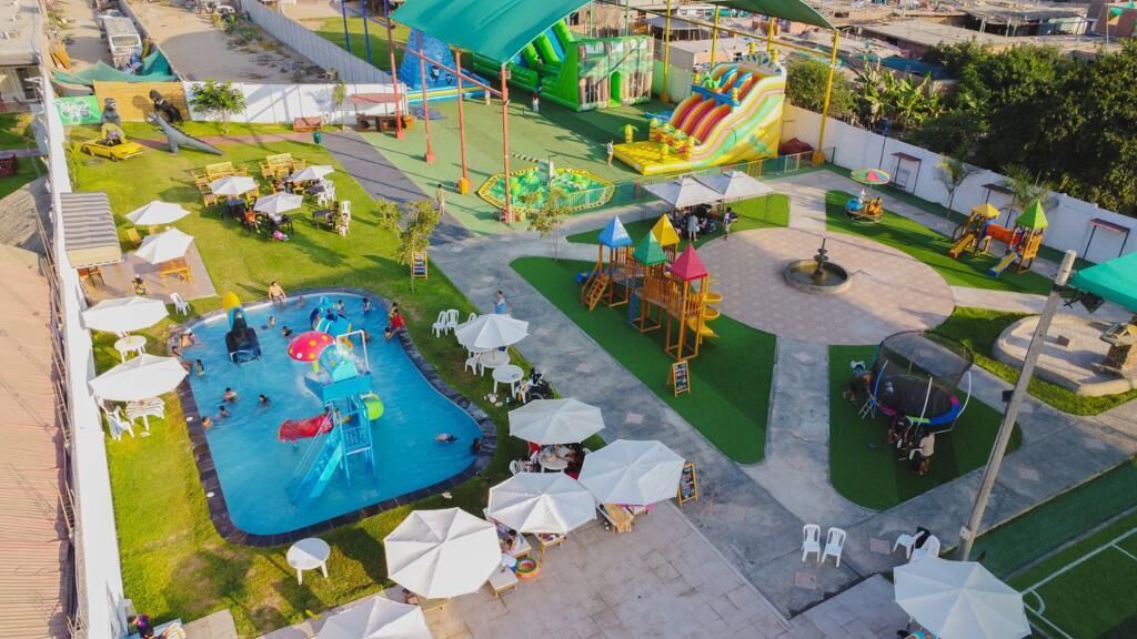 A water park with a swimming pool, slides, and play structures.