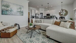 Ein modernes Wohnzimmer mit einer Couch, einem Couchtisch und einem Bild an der Wand.
