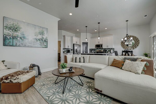 A modern living room with a sofa, coffee table, and a painting on the wall. - *Desert Escape- With a Private Hottub & Firepit* (Washington)