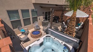Ein Whirlpool mit Sitzgelegenheiten und ein Grillbereich in einem Garten.