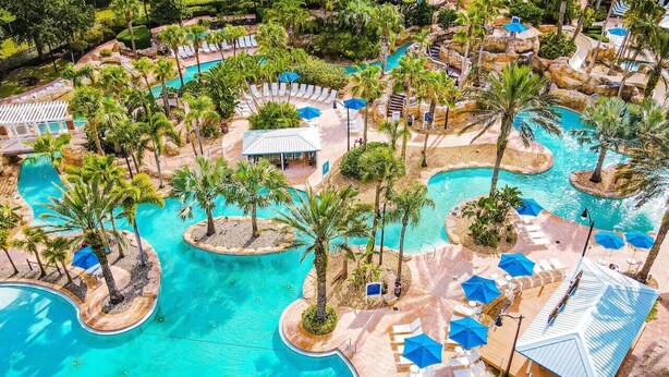 A resort with multiple swimming pools, palm trees, and lounge areas. - Luxury Resort Style Condo Near Disney-103 (Kissimmee)