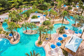 A resort with multiple swimming pools, palm trees, and lounge areas.