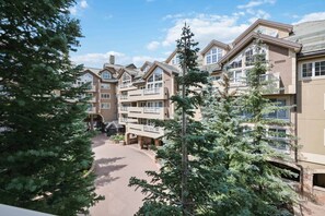 A multi-story hotel with a central courtyard, balconies, and surrounding trees.