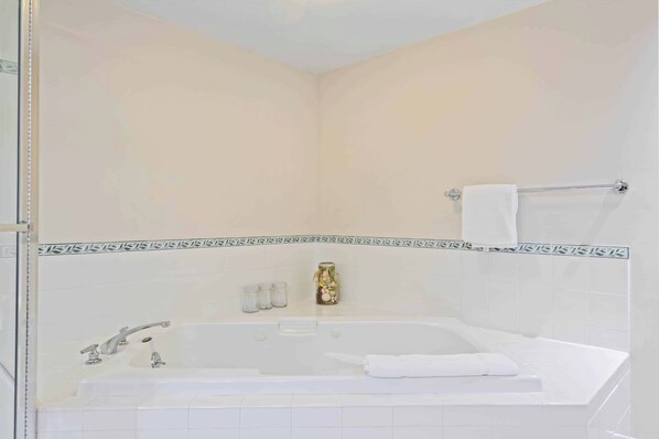 A bathroom with a bathtub, a towel rack, and a decorative item on the wall.