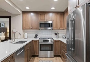 Enjoy cooking in this well-equipped kitchen with a microwave, oven, refrigerator, sink, and faucet.