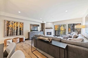 Relax in this stylish living room with a large sofa, coffee table, and fireplace.