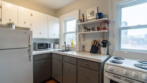 Una cocina equipada con refrigerador, microondas, estufa y armarios.