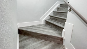 A staircase with wooden steps and white walls. - Charming 4-bedroom Townhouse  25 min from Denver (Northglenn)
