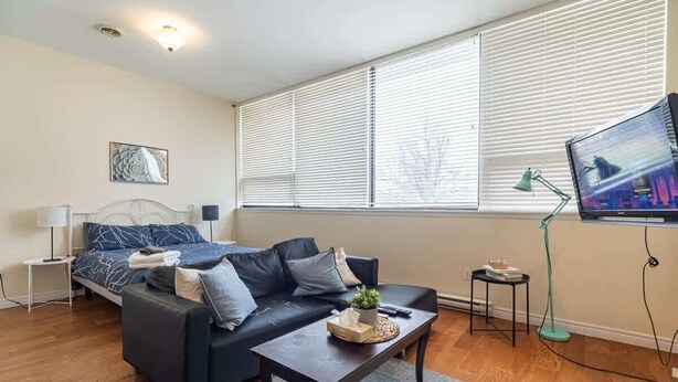 Een moderne woonkamer met een bank, een salontafel, een televisie en een lamp.